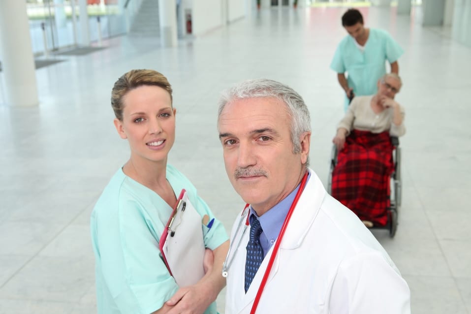 Doctor and nurse in hospital hallway to help illustrate what is practice Management.