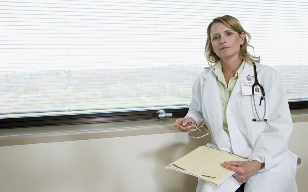 A female doctor sitting next to a window to illustrate RVU in medical billing.